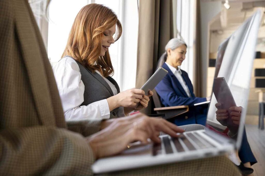 Professionnels en formation utilisant des supports numériques et des documents dans un environnement de travail.