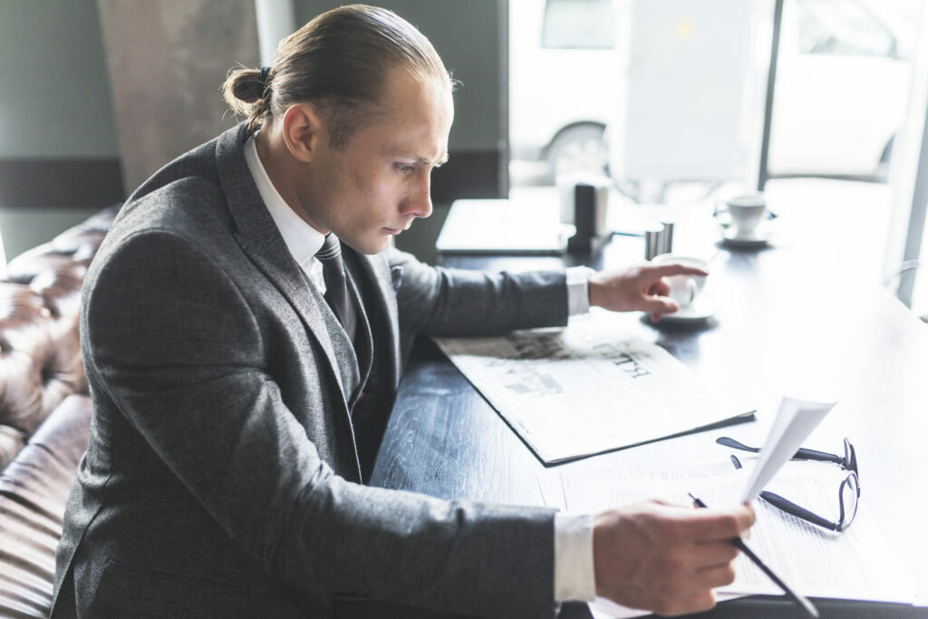 Directeur de réseau analysant des documents et des informations professionnelles à son bureau.
