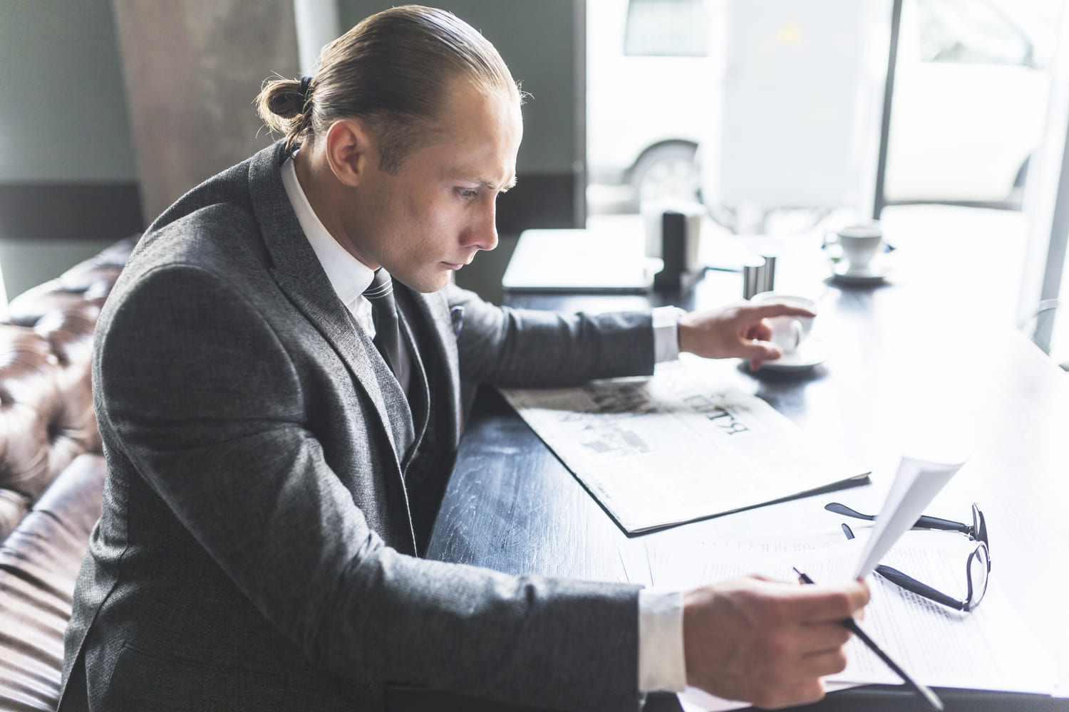 Directeur de réseau analysant des documents et des informations professionnelles à son bureau.