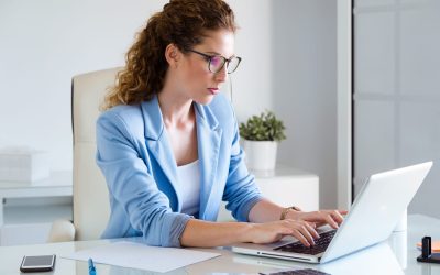 Femme travaillant sur un ordinateur portable dans un environnement professionnel, illustrant la formation et l’apprentissage en ligne.