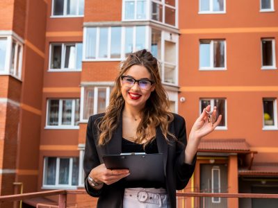 Estate agent with key against new house. Moving home or renting property