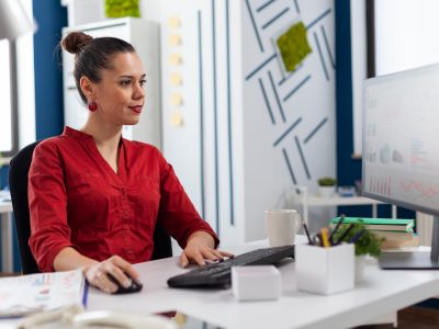Woman entrepreneur working on financial expertise from company office. looking at charts and graphs of start up. Concentrated employee typing on keyboard checking project status.
