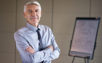 1. Directeur du développement expérimenté, en tenue professionnelle, posant dans un bureau devant un tableau de présentation.
