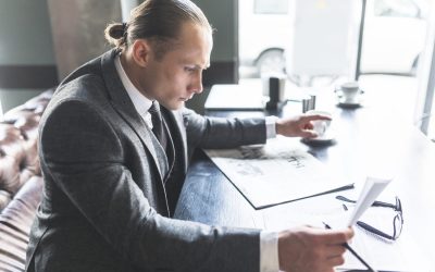 Directeur de réseau analysant des documents et des informations professionnelles à son bureau.