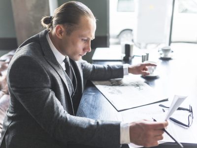 Directeur de réseau analysant des documents et des informations professionnelles à son bureau.