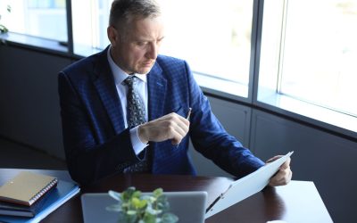 1. Gestionnaire de fortune en costume étudiant des documents financiers à son bureau.