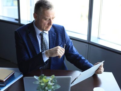 1. Gestionnaire de fortune en costume étudiant des documents financiers à son bureau.