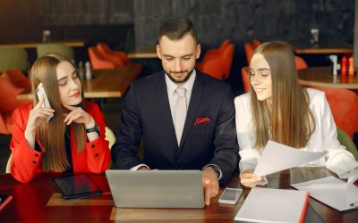 Man and two beautiful women working. People in a cafe. Twins in a elegant suits